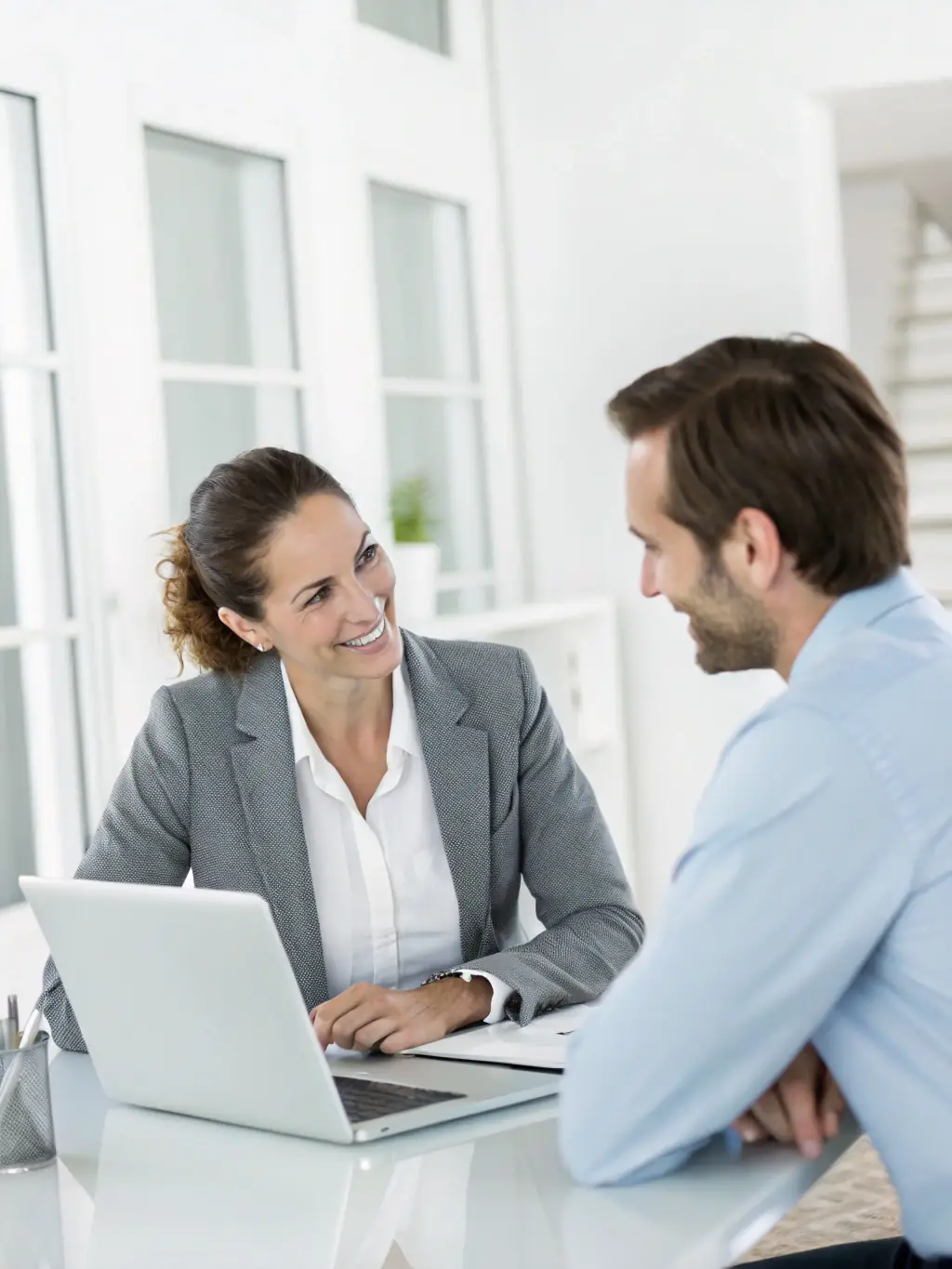 A professional photograph of a real estate agent from ArichyPrive consulting with a property owner in a luxurious setting, discussing market analysis and pricing strategies.